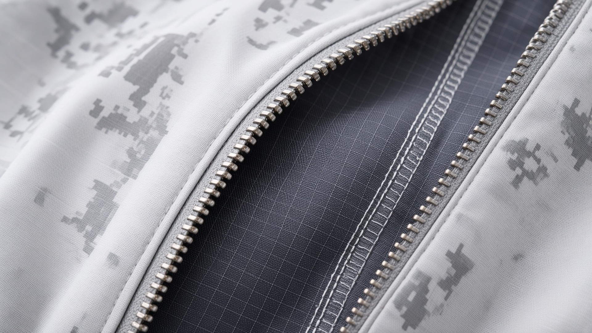 Close-up of the FlySpark anti-thermal suit at an open zip – pearl-white snow digital camo outer shell beside the dark grey ripstop anti-infrared inner layer